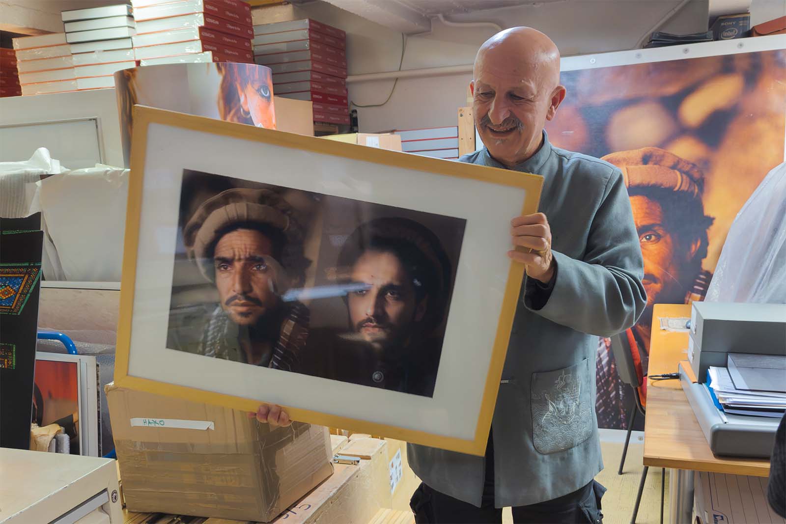 Reza dans son atelier à Paris avec des portraits du commandant Massoud © Stéphan Norsic